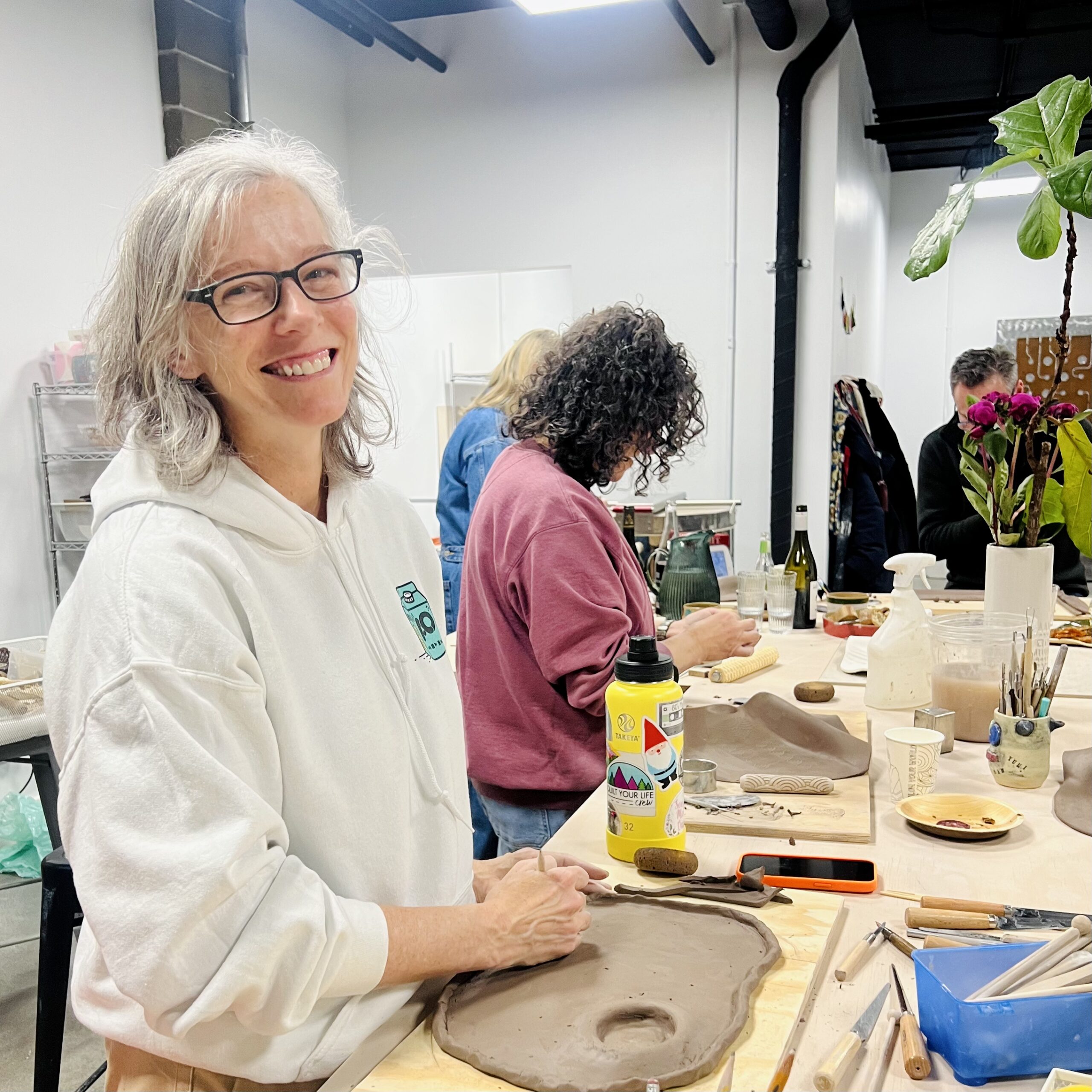 Students sculpting their own charcuterie board during a workshop at slip studio in white plains NY